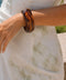 Mavi honey brown faceted acrylic bangle with a glossy translucent finish