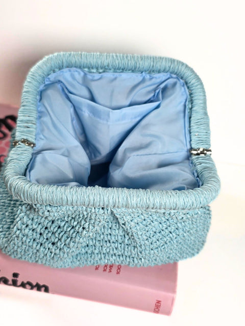 Light blue raffia crocheted clutch bag with matching lining and a single interior slip pocket