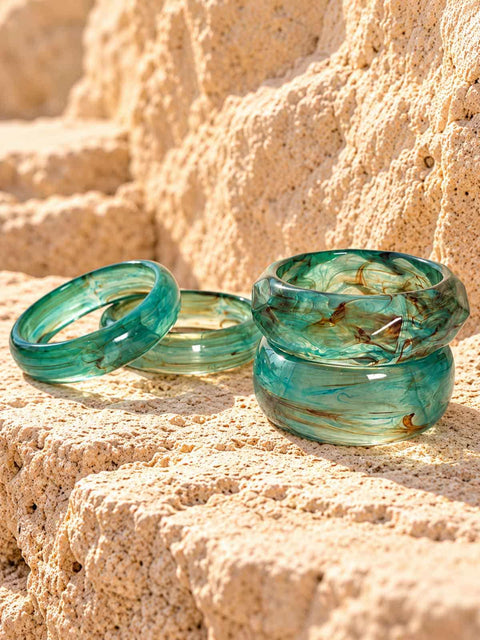 Translucent aqua bangles of all shapes with stubble brown swirls 