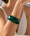 Front view of the Mavi green faceted acrylic bangle with a polished finish