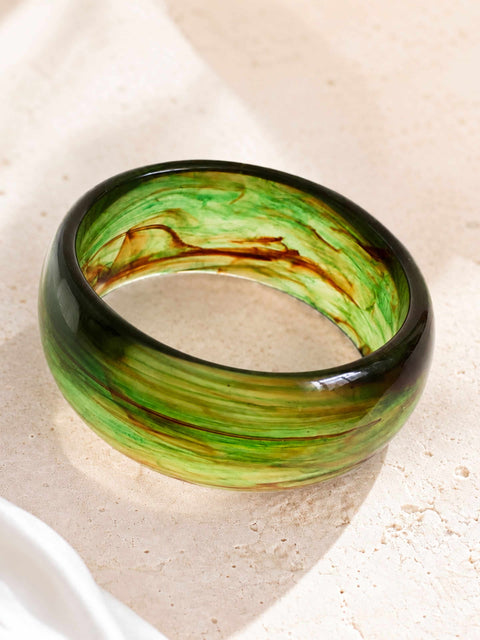 Side view of the Zeni green resin bangle featuring marbled brown swirls