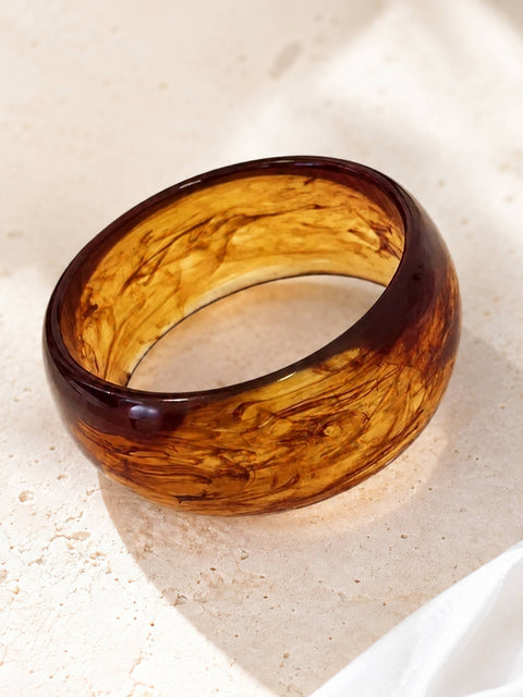 Brown marbled acrylic bangle with a glossy amber finish