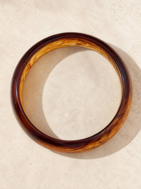 Top view of the Zeni brown acrylic bangle with swirling amber marbled detailing