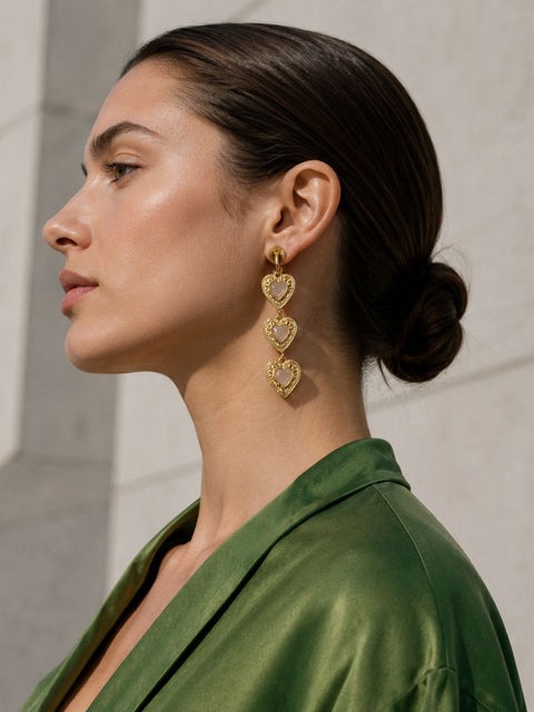 gold heart-shaped drop earring with soft pink centre stones with a gold hear border