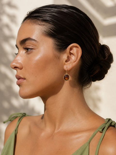 dangle gold earrings with a square  -brown stone in a French hook style 