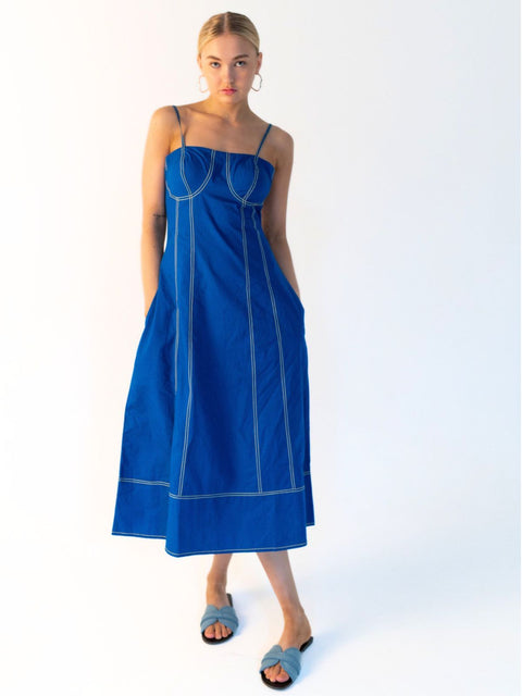 Women's cobalt blue cotton midi dress with a structured bodice, yellow contrast stitching and side pockets