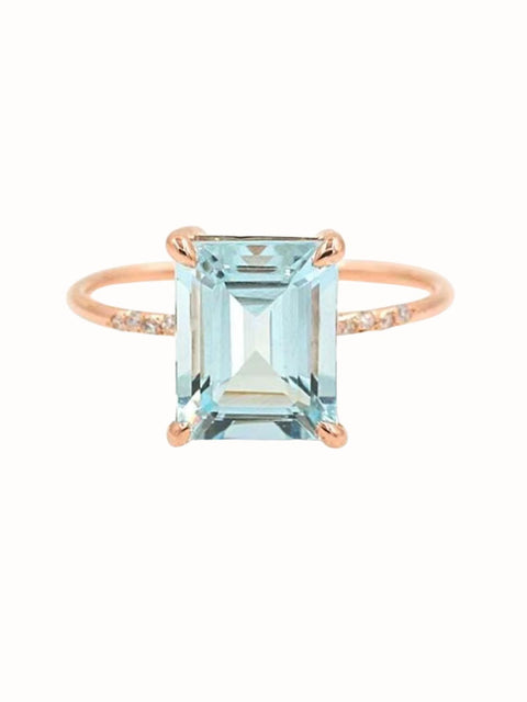 Elegant aqua blue cocktail ring with a faceted rectangular centre stone and delicate gold tone band