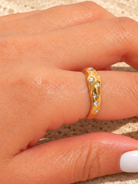 Chunky gold ring with an organic sculptural silhouette and embedded clear stones