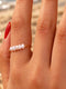 A delicate gold ring adorned with five small white freshwater pearls