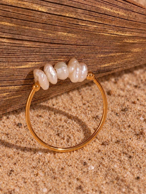 A gold ring featuring five irregular white freshwater pearls along the top
