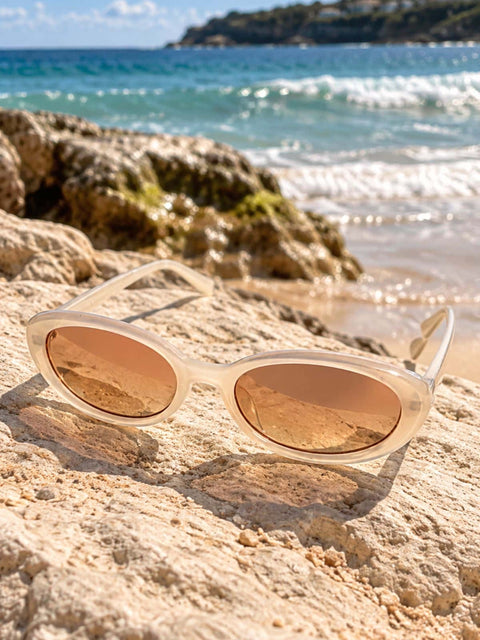 Women's white cat eye sunglasses with warm peach tinted lenses