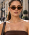 Translucent caramel cat eye sunglasses with brown tinted lenses and angular frames