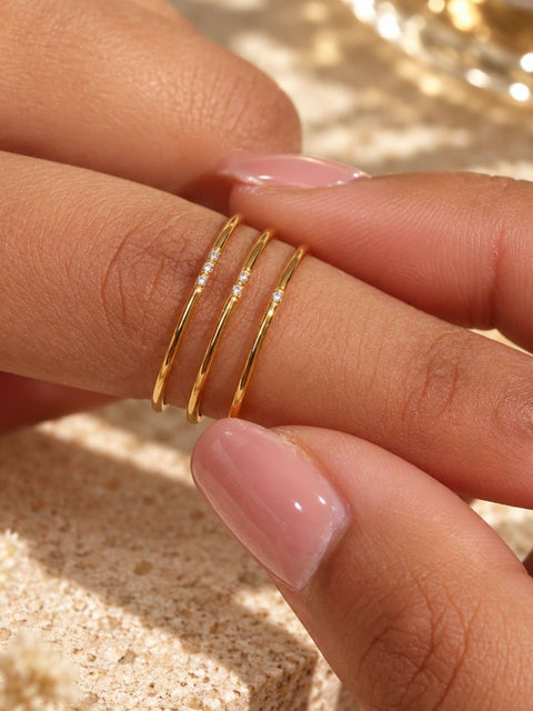 Three set slim gold rings, each ring has  one, two and three small clear stones for each ring